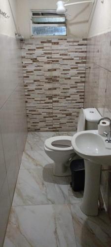 a bathroom with a toilet and a sink at Casa Vó Amélia in Aparecida