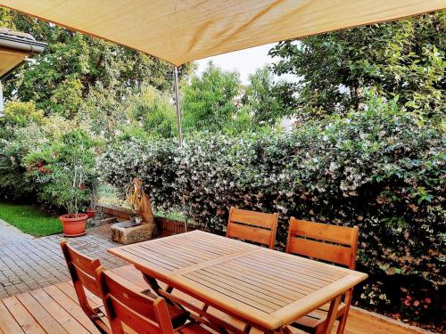 a wooden table and chairs under an umbrella on a patio at Casa Cecilia in Novellara
