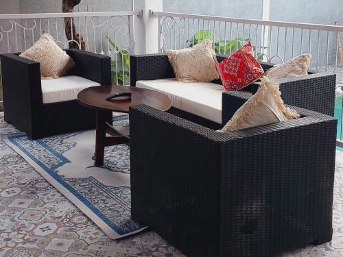 a porch with two wicker chairs and a table at Home Villa in Lovina