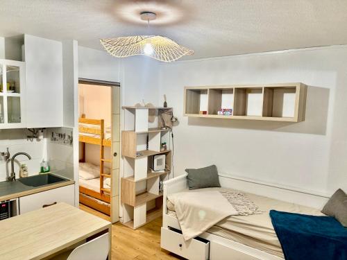 a small room with a bed and a kitchen at Studio Chaleureux au Cap d’Agde in Cap d'Agde