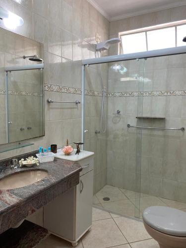 a bathroom with a shower and a sink and a toilet at Na Boca do Jacaré in Caraguatatuba