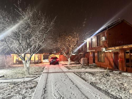 a car parked next to a building in the snow at Hovakimyans Hotel And Pool N1 in Yerevan Parakar