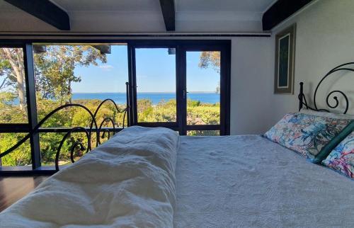 una camera da letto con un letto e vista sull'oceano di Hawkesview a Vincentia
