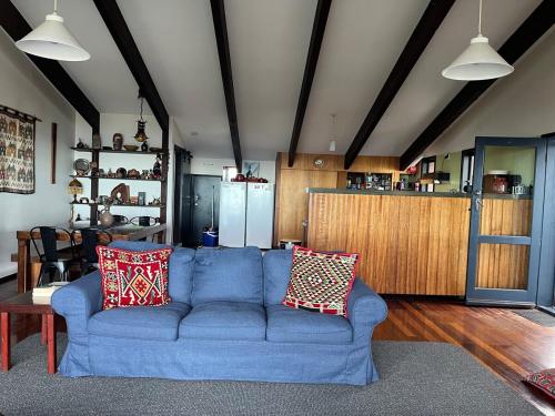 un soggiorno con un divano blu e una cucina di Hawkesview a Vincentia