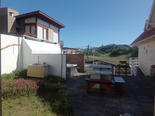 een achtertuin met een picknicktafel en een gebouw bij La posada del Nono in Villa Gesell