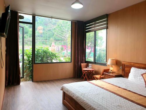 a bedroom with a bed and a large window at Ngòi Xanh Ecolodge (Bungalow - Restaurant - Coffee) in Tuyên Quang