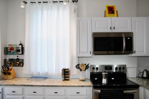 a kitchen with white cabinets and a black counter top at Wooster Square Gems in New Haven