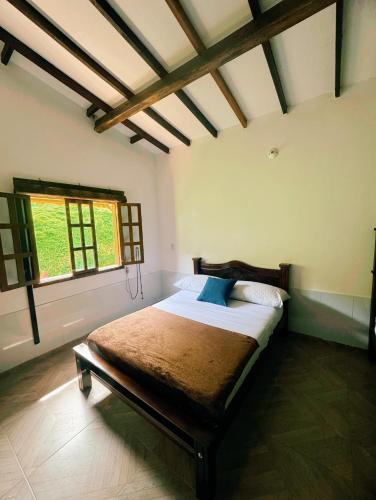 a bedroom with a bed in a room with a window at Cabaña La Sanguina 4 Pax in Ocaña