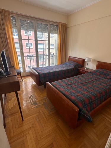 a hotel room with two beds and a television at Amplio depto de 2 habitaciones céntrico muy buena ubicacion in Mar del Plata