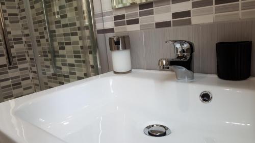 a white bathroom sink with a soap dispenser on it at BSuites Apartment in Padova
