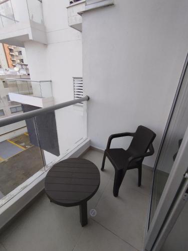 a chair and a table in a room with a window at Apartaestudio Jacuzzi Centro Comercial Gimnasio ALTOPRADO in Barranquilla