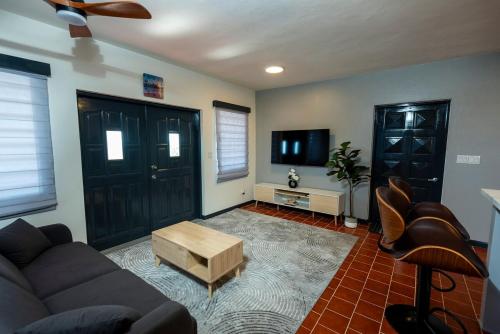 a living room with a couch and a tv at Deany's Uptop Luxury Suite in The Valley