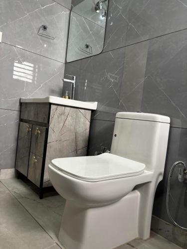a bathroom with a toilet and a sink and a mirror at Yb home2 in Rāthdhana