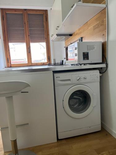 a kitchen with a washing machine and a microwave at Bagnuz's Home in Scandicci