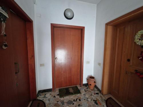 a hallway with a wooden door and a clock on the wall at Bagnuz's Home in Scandicci