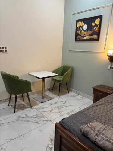 a room with two chairs and a table and a bed at Yb home2 in Rāthdhana