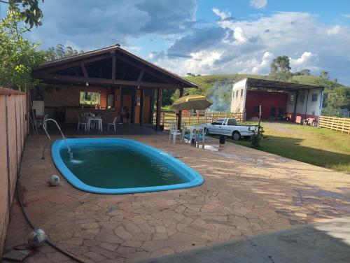 a swimming pool in a yard with a house at Chácara Lopes in Cambuí