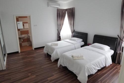 a room with two beds and a bathroom with a window at D'PrinceDream in Port Dickson