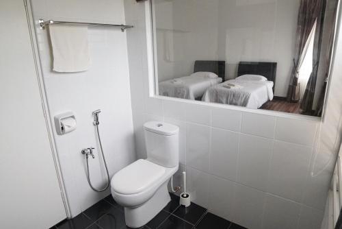 a bathroom with a white toilet and a mirror at D'PrinceDream in Port Dickson