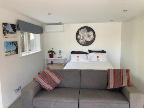 a living room with a couch and a bed at Unit at Kohimarama in Auckland