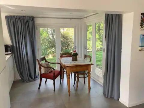 a dining room with a table and chairs and windows at Unit at Kohimarama in Auckland