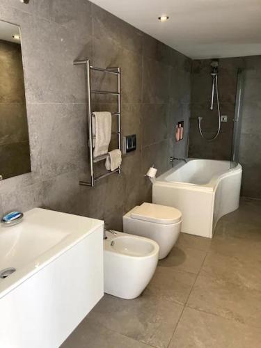 a bathroom with a sink and a toilet and a bath tub at Unit at Kohimarama in Auckland
