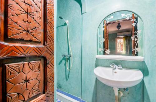 une salle de bain avec un lavabo et un miroir dans l'établissement Riad Golden Palm, à Marrakech