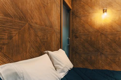 a bed with a wooden headboard and a white pillow at ZEN & ART - Alojamento de Charme in Santa Maria da Feira