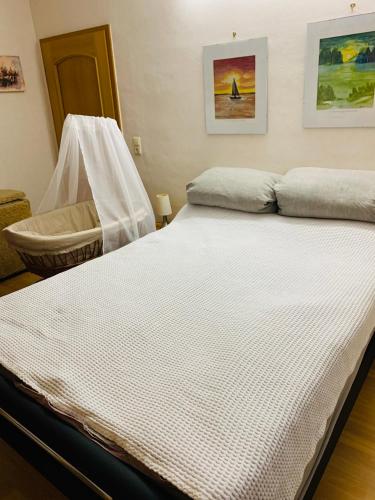 a large white bed in a bedroom with a chair at Ferienwohnung Juttchen in Roßleben