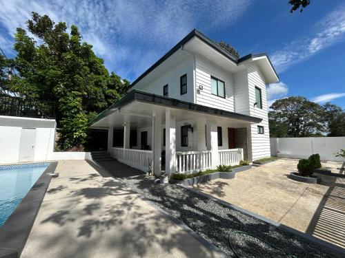 Sofias Private Farm House في Alfonso: منزل أبيض اللون مع مسبح أمامه