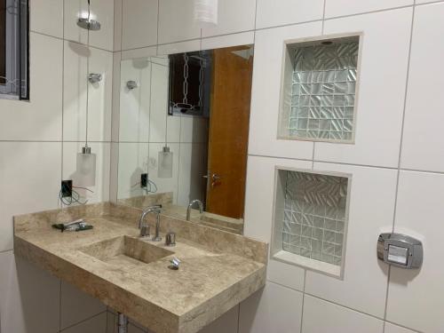 a bathroom with a sink and a mirror at Chácara da Acácias in Sao Jose do Rio Preto