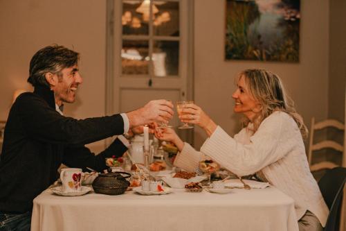 a man and woman sitting at a table drinking wine at La Maison du Village in Saint-Rémy-de-Provence