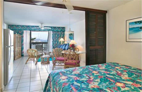 um quarto com uma cama e uma sala de jantar em Sapphire Beach Resort em East End