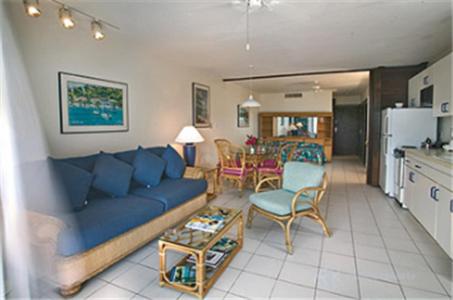 a living room with a blue couch and a kitchen at Sapphire Beach Resort in East End