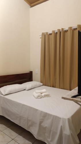 a bedroom with a bed with two towels on it at Hostel X DE CARAIVA in Caraíva