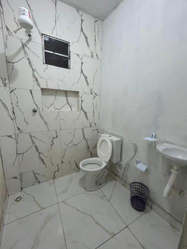 a bathroom with a toilet and a sink at Residencial Praia Quente casas in Nova Viçosa