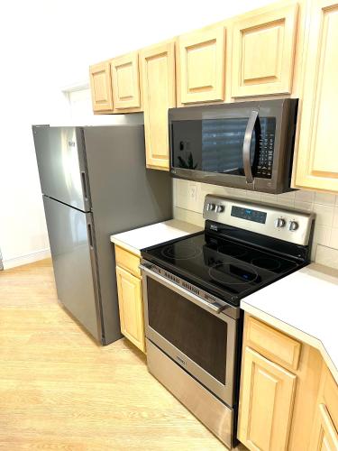a kitchen with stainless steel appliances and wooden cabinets at Albatross Condo in PGA Village, 2 bedroom 1 bath, A Side in Carlton