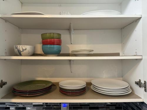 a cabinet filled with plates and bowls on shelves at Park Avenue Beauty in Foley