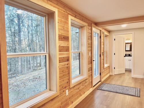 a room with wooden walls and large windows at Chickadee A-Frame in Freeport