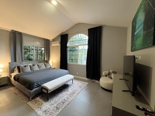 a bedroom with a bed and a chair and a window at Casa Coco in Valle de Anton