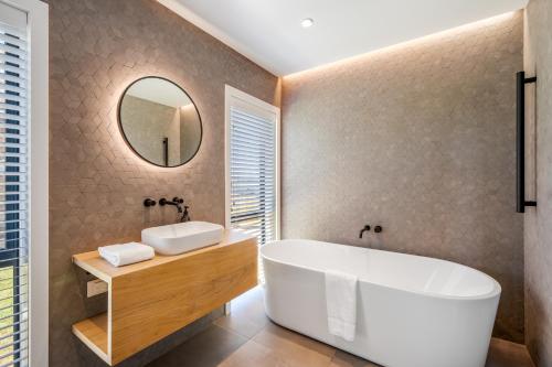ワナカにあるCoco Chalet by Sotheby's Luxury Rental Homesのバスルーム(大型バスタブ、鏡付)