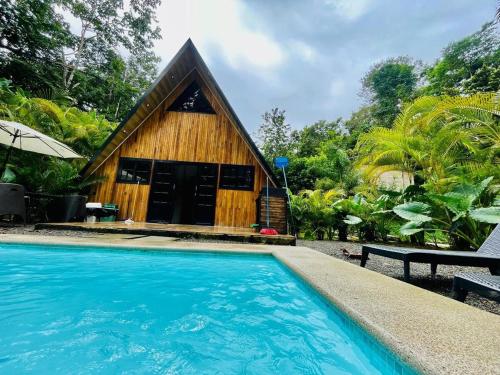 een klein gebouw met een zwembad voor een huis bij Casa Alpina in Talamanca