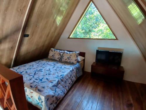 een kleine slaapkamer met een bed en een raam bij Casa Alpina in Talamanca