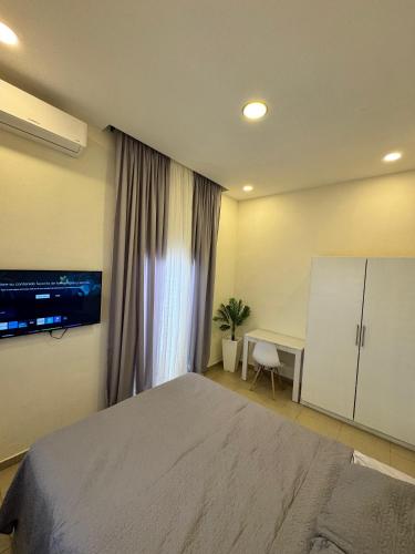 a bedroom with a bed and a desk and a window at Casa cómoda cerca Aeropuerto Palmerola fácil acceso in Comayagua