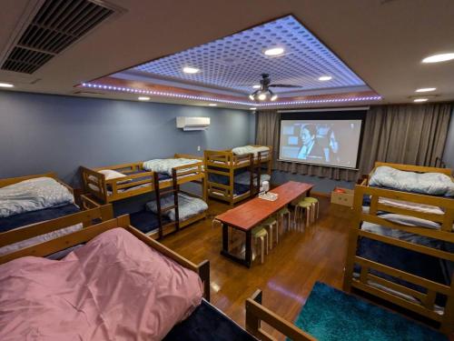 大山町にある大山ベースキャンプ Daisen Basecampのベッド数台とプロジェクションスクリーンが備わる客室です。