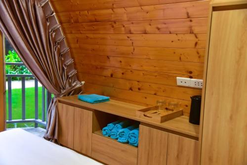 a bedroom with a wooden wall with a bed and a drawer at The Vista Beach Resort Phan Thiết in Phan Thiet