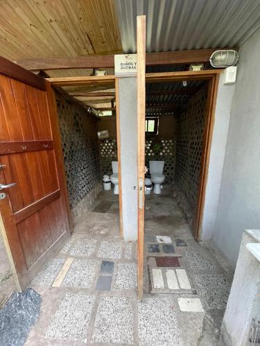 an entrance to a bathroom with two toilets at Casa Qinti EcoHostel in Cosquín