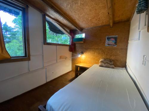 een slaapkamer met een bed in een kamer met een raam bij Cabaña Iris in La Paloma