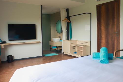 a bedroom with a bed with a tv and a mirror at The Vista Beach Resort Phan Thiết in Phan Thiet