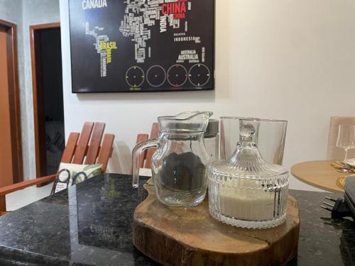 a glass jar on a wooden cutting board with a table at Apartamento no Centro in Palmas